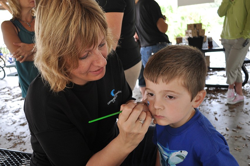 Karissa Miller painted a shark on the face of Louis Panico, 4.
