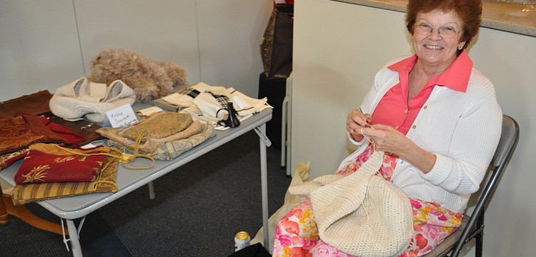 Arlene Scarlett in action near her totes and handbags