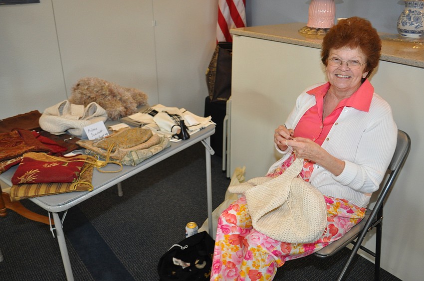 Arlene Scarlett in action near her totes and handbags