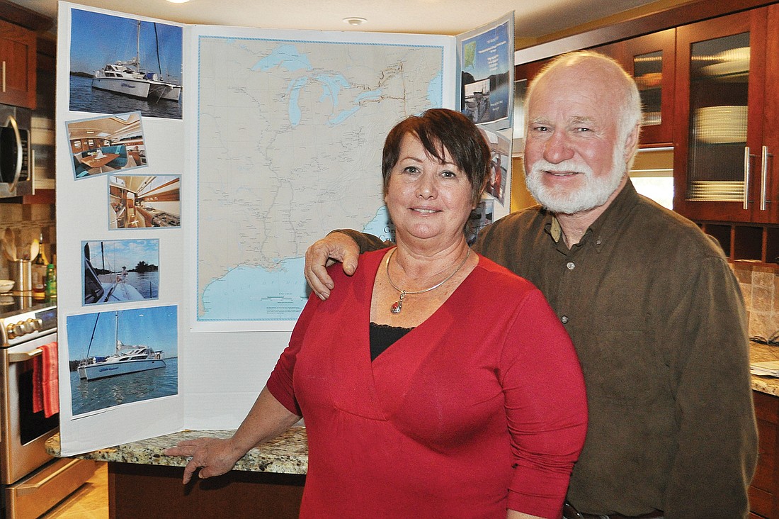 Jean and Ron Schwied stand in their kitchen in front of a map of the route they will be taking. Their home is rented out, and they are ready to take off.