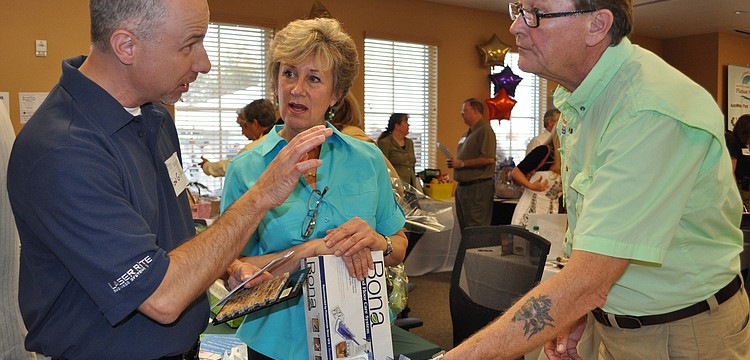 Ron Griffin checked out flooring made of coconut shown by Montgomery's Carpet Plus designer Lynn Johnson and manager George Garmon.