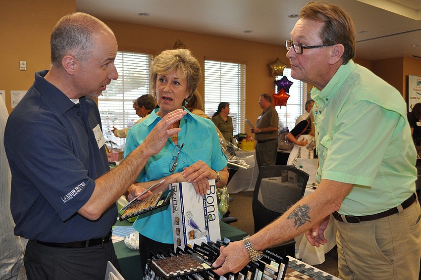 Ron Griffin checked out flooring made of coconut shown by Montgomery's Carpet Plus designer Lynn Johnson and manager George Garmon.