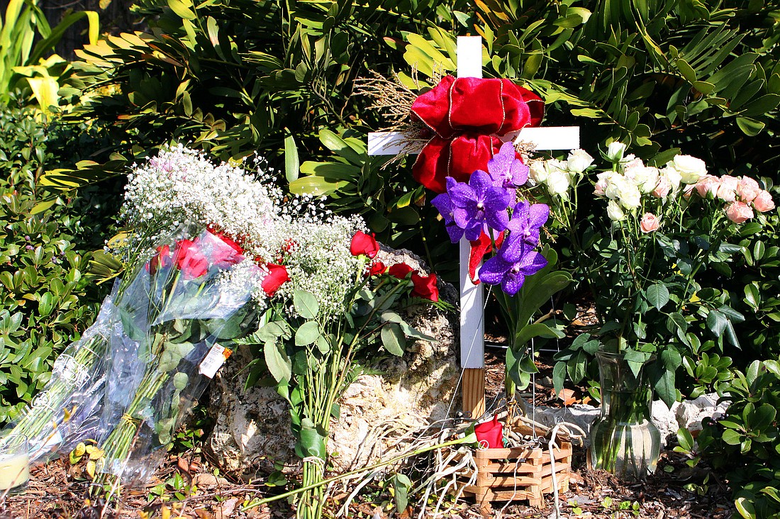 The day after 53-year-old Donna Chen was killed in a traffic incident on Midnight Pass Road, residents left flowers and a cross as a memorial to her. Photo by Rachel S. O'Hara.