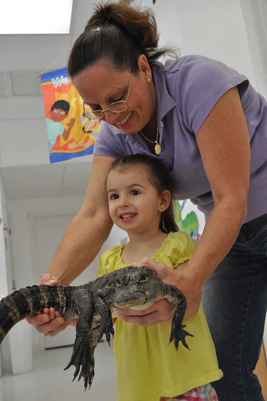 Two-year-old Natalee Wren held the alligator with the help of teacher Elaine Dobransky.