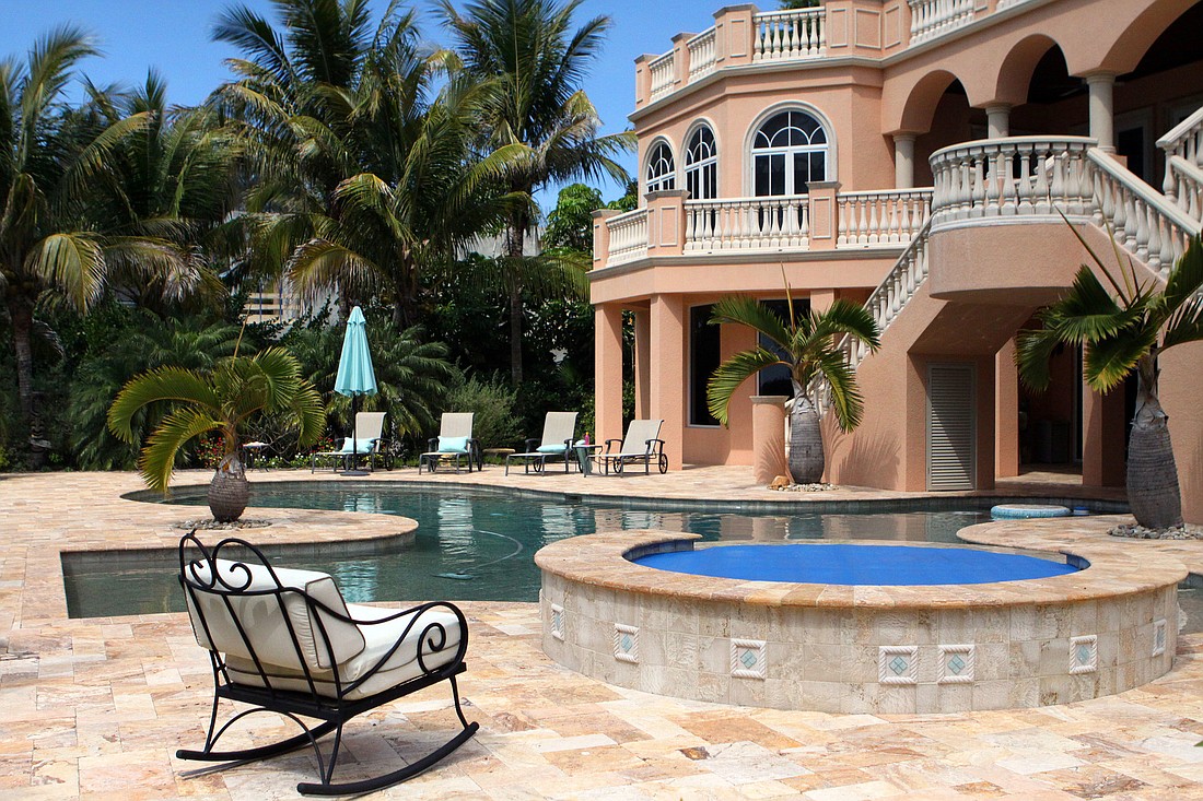 The JohnsonsÃ¢â‚¬â„¢ backyard features a pool and hot tub with plenty of lounge chairs and palm trees.