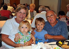 Sharon and Frank Santo pose with their grandchildren Sami, 17 mos., and Evan, 4, Friday, March 23, at St. Michael the Archangel's Lent dinner.