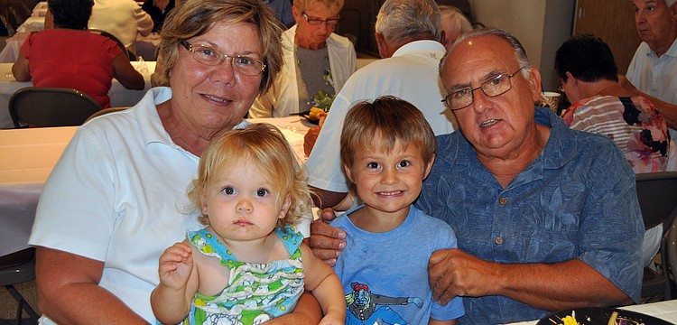 Sharon and Frank Santo pose with their grandchildren Sami, 17 mos., and Evan, 4, Friday, March 23, at St. Michael the Archangel's Lent dinner.