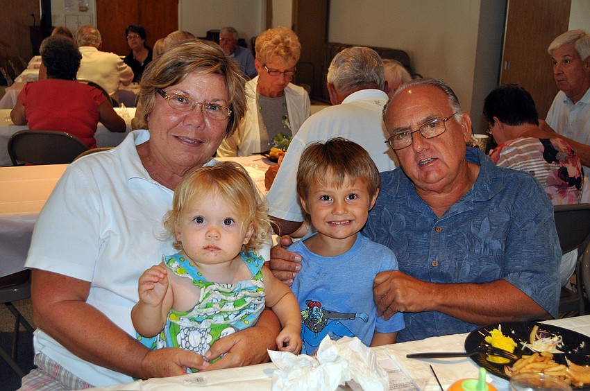 Sharon and Frank Santo pose with their grandchildren Sami, 17 mos., and Evan, 4, Friday, March 23, at St. Michael the Archangel's Lent dinner.