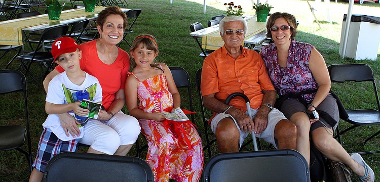 Jack Slavinski, 4, Carolyn Folkman, Lily Slavinski, Frank DeAngelo and Stephanie Slavinksi sit in the shade under the tent.