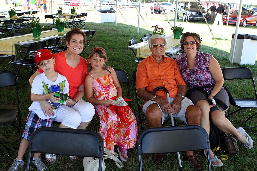 Jack Slavinski, 4, Carolyn Folkman, Lily Slavinski, Frank DeAngelo and Stephanie Slavinksi sit in the shade under the tent.