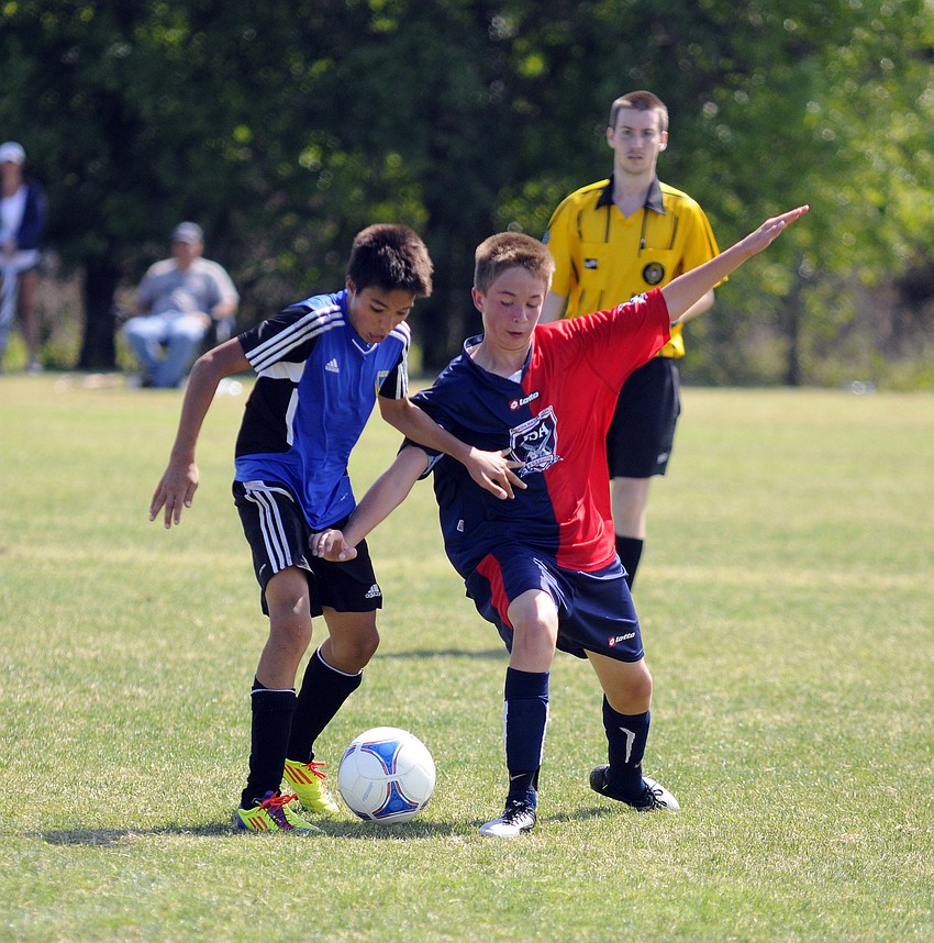 Doral Unitedâ€™s Victor Herrera and Florida Soccer Allianceâ€™s Austin Cole battle for position.