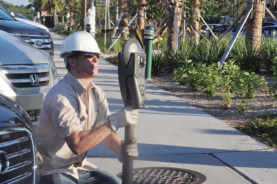 A city of Sarasota worker installs the first parking meter on the Circle Monday morning.