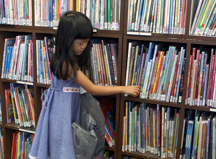 Felicity Lui, 4, reaches for an egg on the bookshelf.