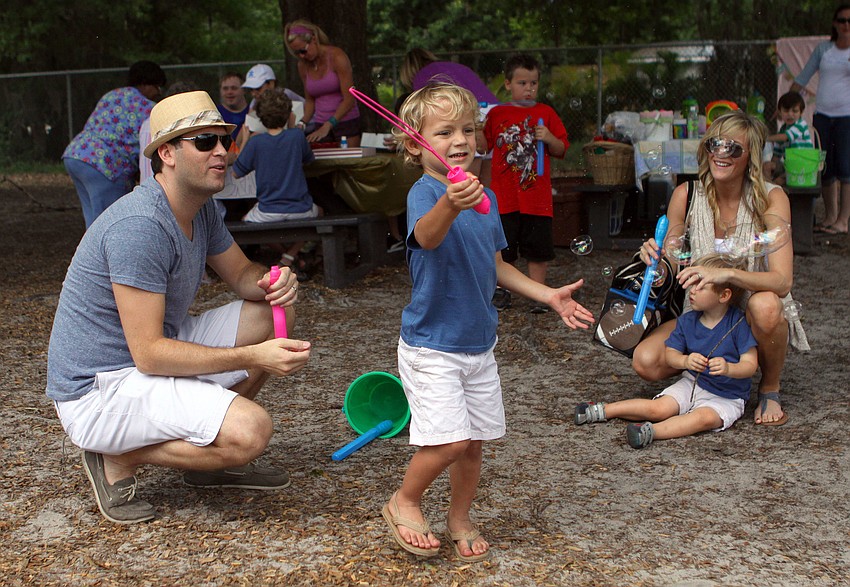 JJ Weatherbie, 3 Â½, makes bubbles while his father, Jonas, mother, Brittany, and brother, Braxton, 2 Â½, look on, Saturday, March 31, at the Face Autism Egg Hunt at Ashton Elementary.