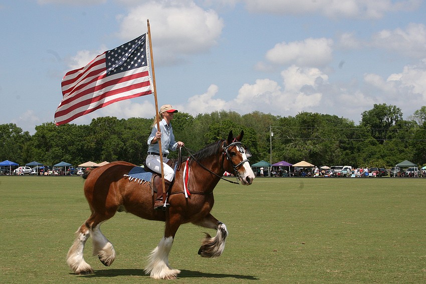 The Polo Grill and Barâ€™s Julia Schroeder presented the colors atop a Clydesdale.
