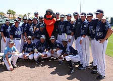 The SCF Manatees pose with The Oriole Bird before the start of SCF v. Orioles charity baseball game, Tuesday, April 3, at Ed Smith Stadium.