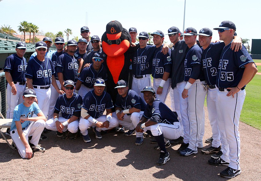 The SCF Manatees pose with The Oriole Bird before the start of SCF v. Orioles charity baseball game, Tuesday, April 3, at Ed Smith Stadium.