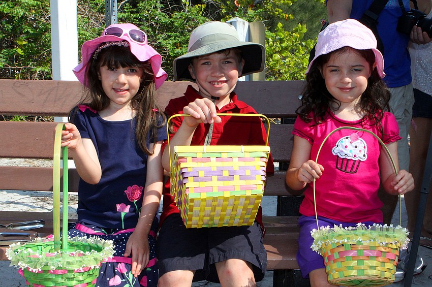 Isabella Sanchez, 4 Â½, Zack Sanchez, 7, and Portia Sanchez, 4 Â½, sit together on a bench while they wait for their turn to go find Easter eggs.