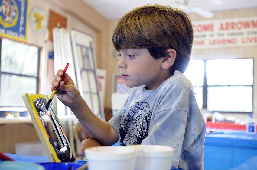 Six-year-old Scott Wolf carefully painted his picture frame.