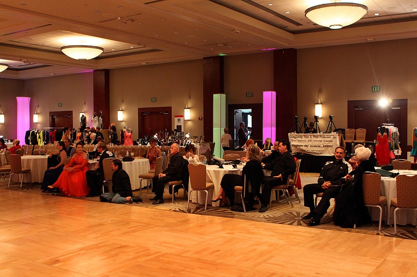 Dancers watch and wait to perform from tables set up along side the ballroom floor.