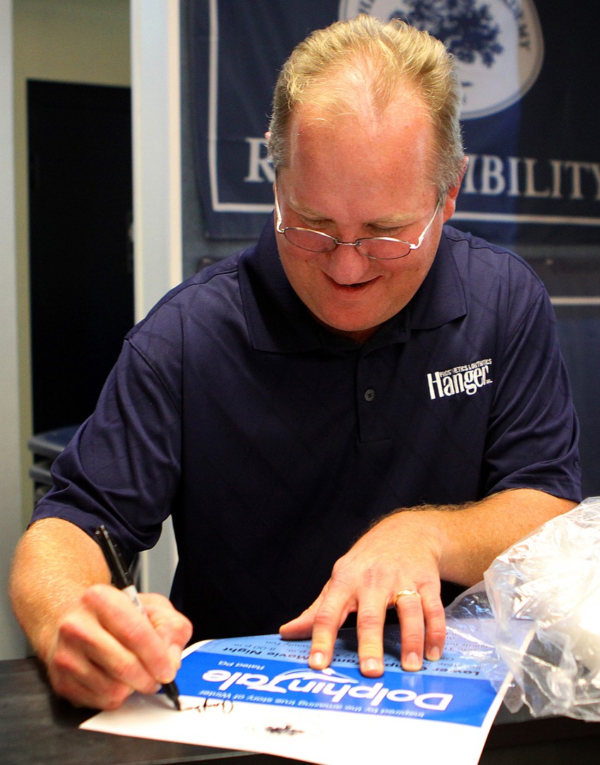 Dan Strzempka signs one of Out-of-Door Academy's 