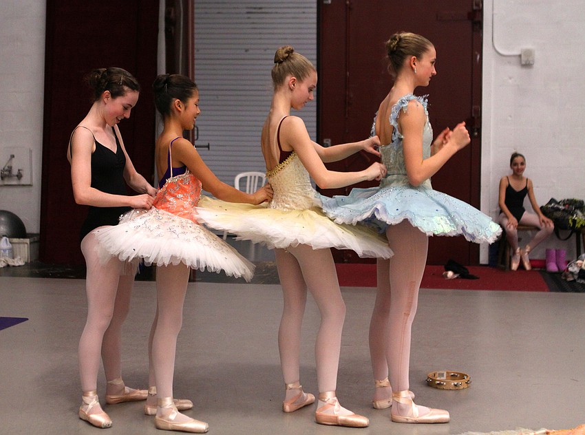 Allison Forsyth, 15, helps Rachel Silverman, 11, into her costume while Silverman helps Caitlin Gish, 13, into her costume and Gish helps Nikki Jennings, 14, into her costume as Athena Kavis, 13, looks on during a dress rehearsal, Wednesday, Jan. 18.