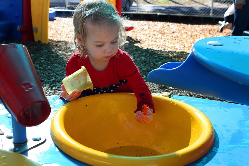Ella Ramos, 18 mos., plays in one of the new water tables.