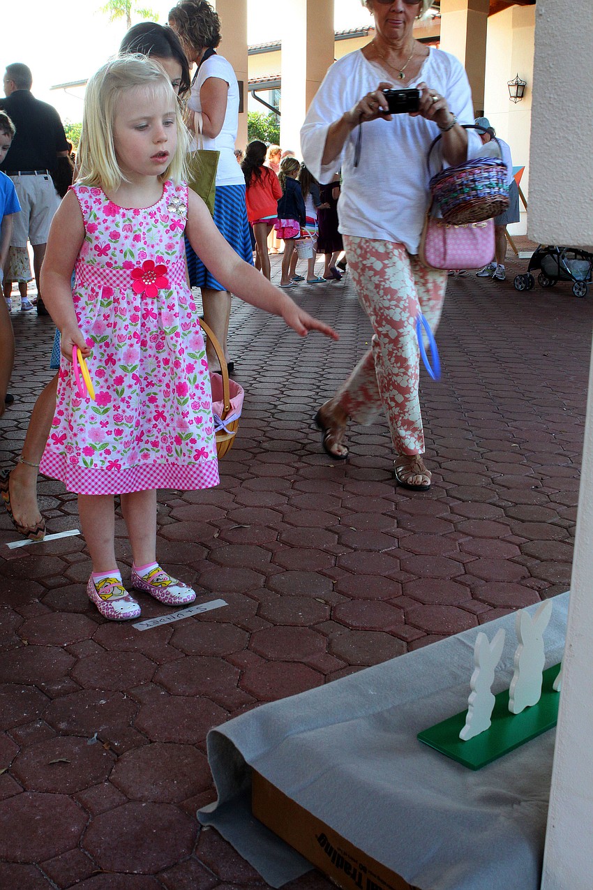 Lexi Searey, 4, plays a ring toss game during the Easter egg hunt at St. Michael the Archangel.
