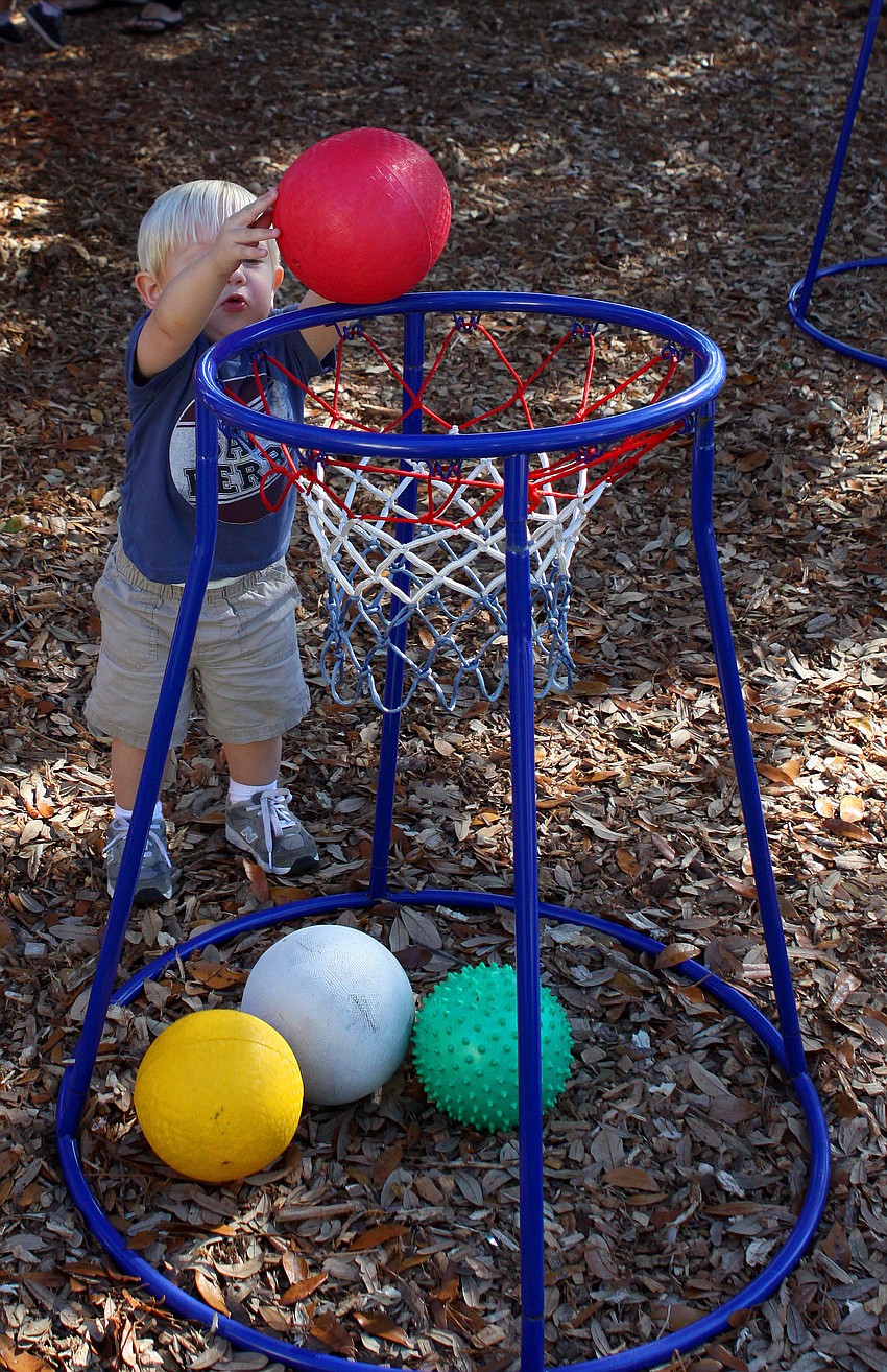 Wynn Watson, 18 mos., scores a basket on one of the new basketball hoops at Forty Carrots.