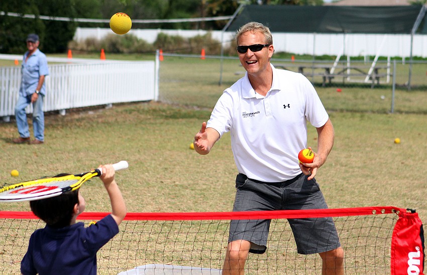 Coach Scott Treibly feeds a ball to Alexander Smith, 4, Tuesday, March 20, at New Gate.