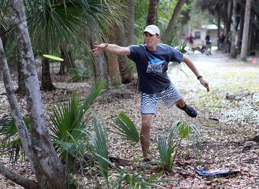Bryan Moore, the organizer of the tournament, throws his disc towards the basket.