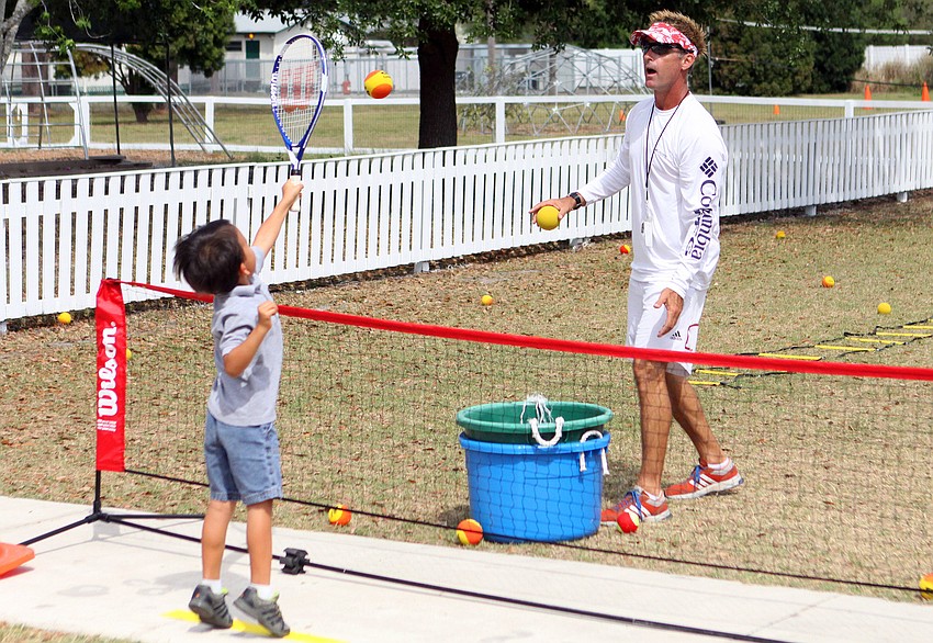 Anthony Tan, 5, hits a volley back to Coach Dave Villani.