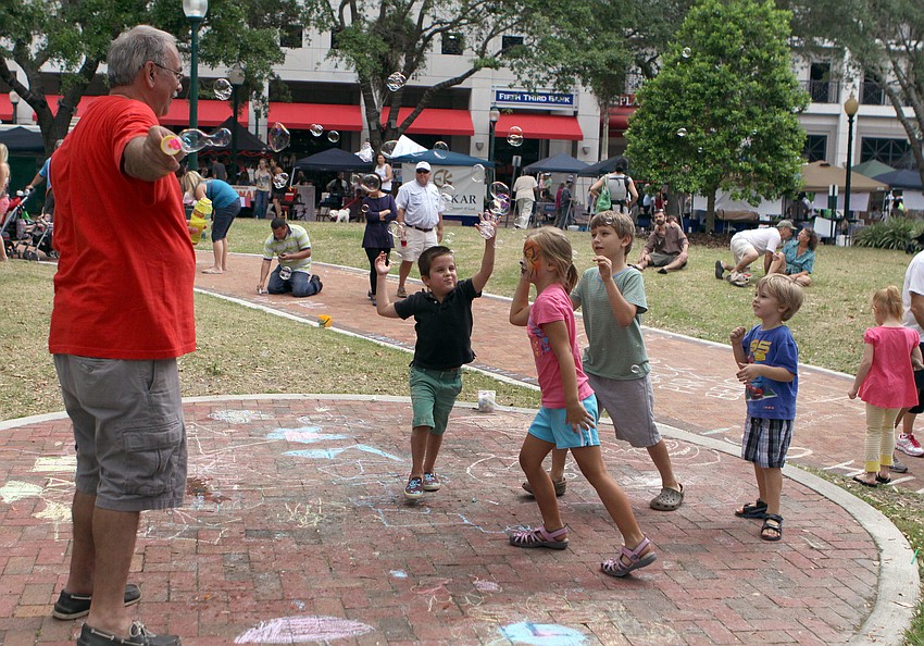 Joe Jacco creates bubbles for some kids to play with at Five Points Park, Saturday, April 14, during EcoFest.