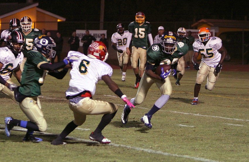 Brian Ragone, 12, tries to hold off Jalen Holmes, 6, as Fred Porter, 88, makes his way down the field with the ball.