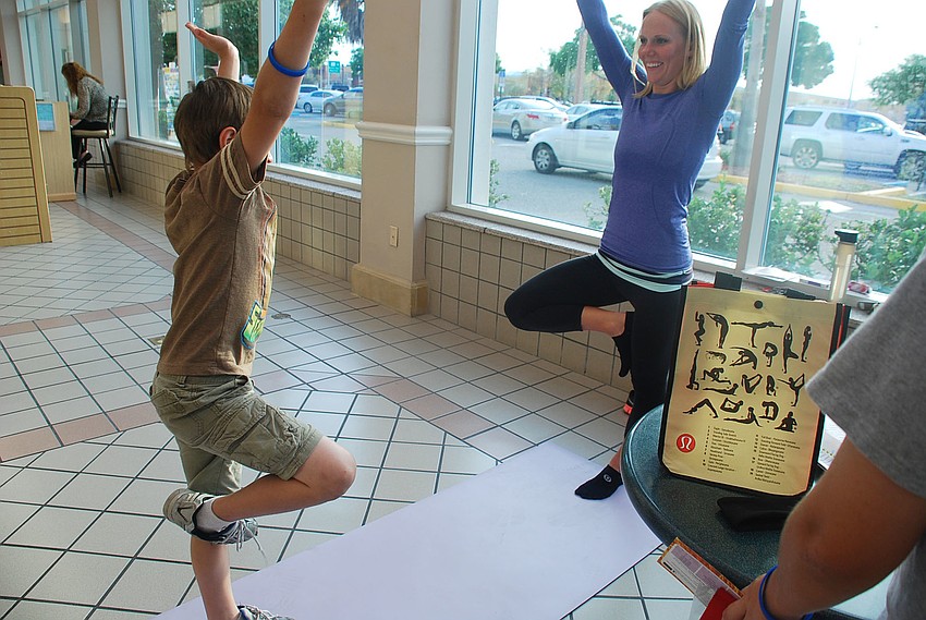 Daniel Asanakas doing a yoga pose with Lululemon instructors