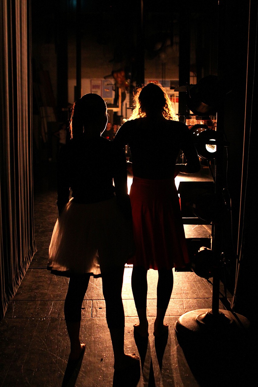 Two VPA dance students watch their friends from the wings, Thursday, March 29, during the Spring Dance Performance at Booker High School Auditorium.