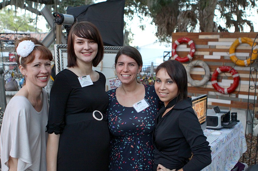 Cat Pennenga, Ciera Coleman, Laura Gilkey and Monica Bello pose in front of the photo booth that was set up out in the back of Sarasota Architectural Salvage during the 3rd annual 