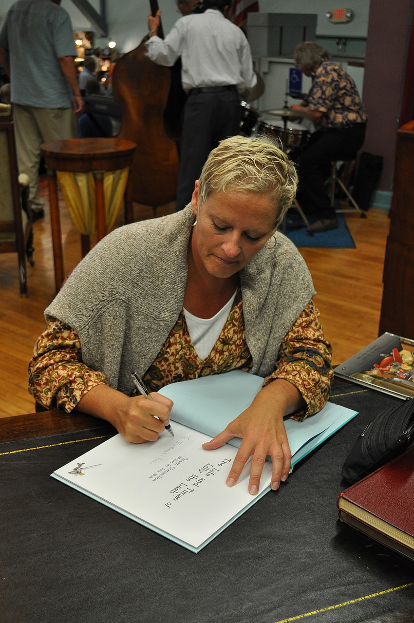 Childrenâ€™s book author Julie Woik signs copies of her books.
