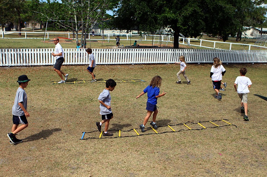 The 6-9 year olds run around the agility course.