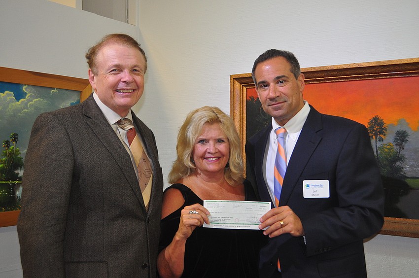 Longboat Key Club General Manager Jeff Mayers, far right, presents Larry Thompson and Jane Buckman a $10,000 donation for the Longboat Key Club Center for the Arts.