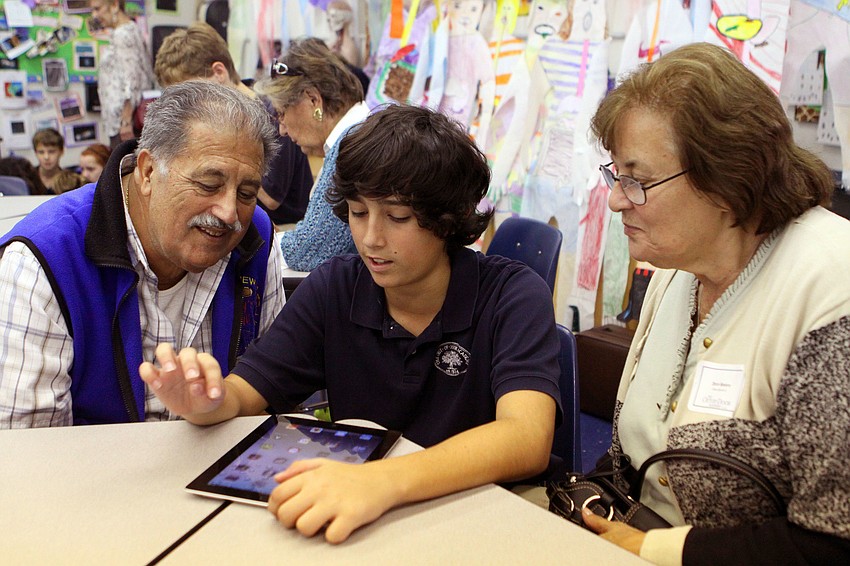 Drew Bavaro, 6th grade, shows his grandparents, Vito and Dora Bavaro, how to work the iPad 2.