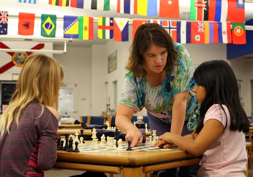 Pamela Doty, 3rd grade teacher and chess club advisor, helps Morgan Smith and Vanessa Aparicio, Saturday, Feb. 11, in the library at Phillippi Shores Elementary.
