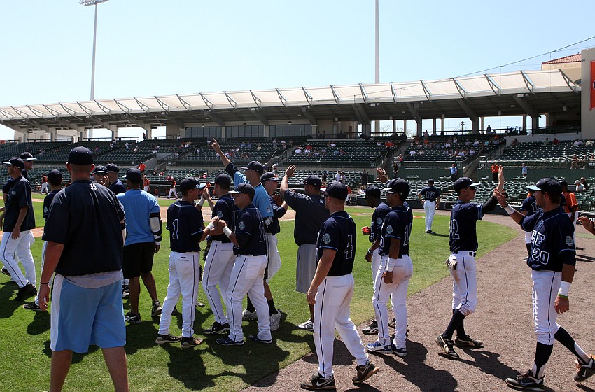 The SCF Manatees celebrate their 2-1 victory out on the field with high fives and cheering.
