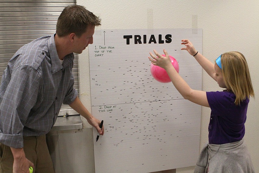 Ava Tomlin, 9, drops a pink ball while Andy Truex prepares to mark how high the ball bounced, Thursday, Feb. 16, during Science Night at Southside Elementary.