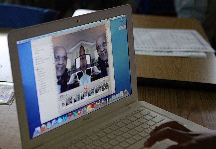 E. Melvin Lloyd and Tyler Wade, 10, have fun taking silly photos with the Mac Photo Booth application.