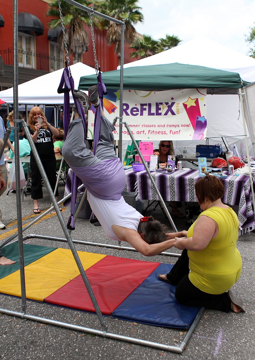 Mary Anne Watson gets some help from Courtney Mendez while trying out a stretch doing aerial yoga, Saturday, April 14.