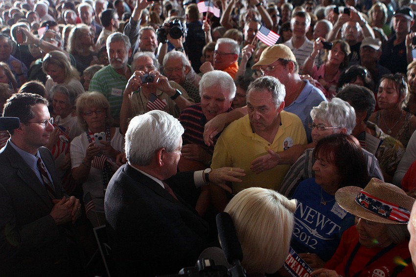 Newt Gingrich shakes hands with people in the crowd as he makes his way back towards his bus after speaking, Tuesday, Jan. 24, at Dolphin Aviation.