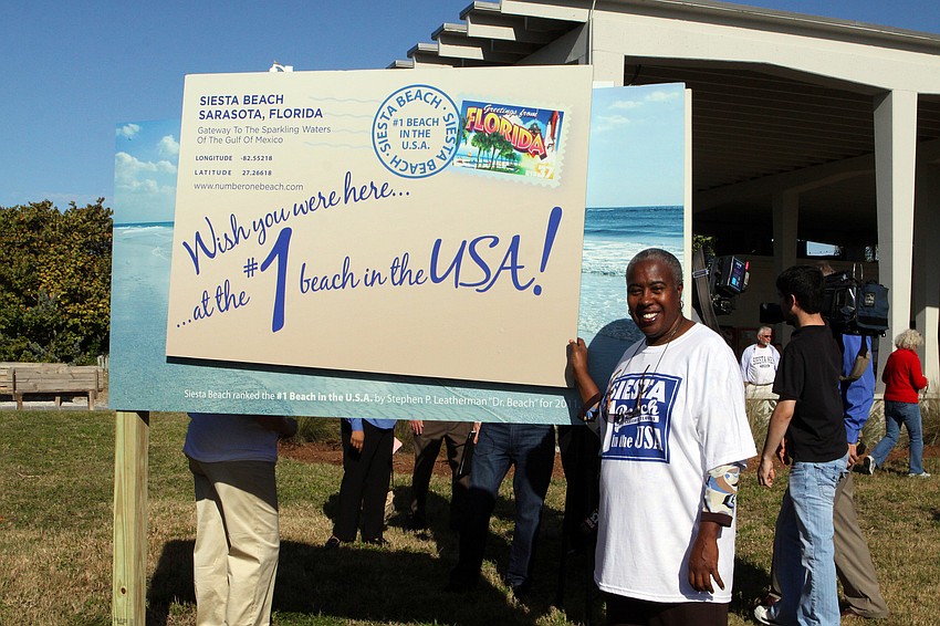 Carolyn Mason poses with the back of the new Siesta Key beach sign.
