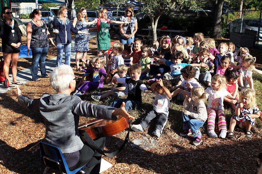 Betsy Kane-Hartnett leads the kids in singing songs about the sun during the playground renovation ceremony, Tuesday, Jan. 24, at Forty Carrots.