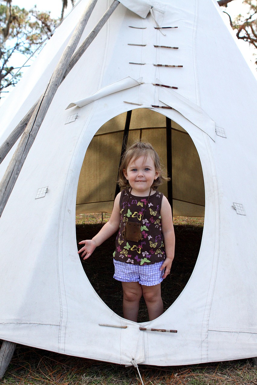 Alexis Alderton, 2 1/2, stands inside a teepee with her totem pouch around her neck.